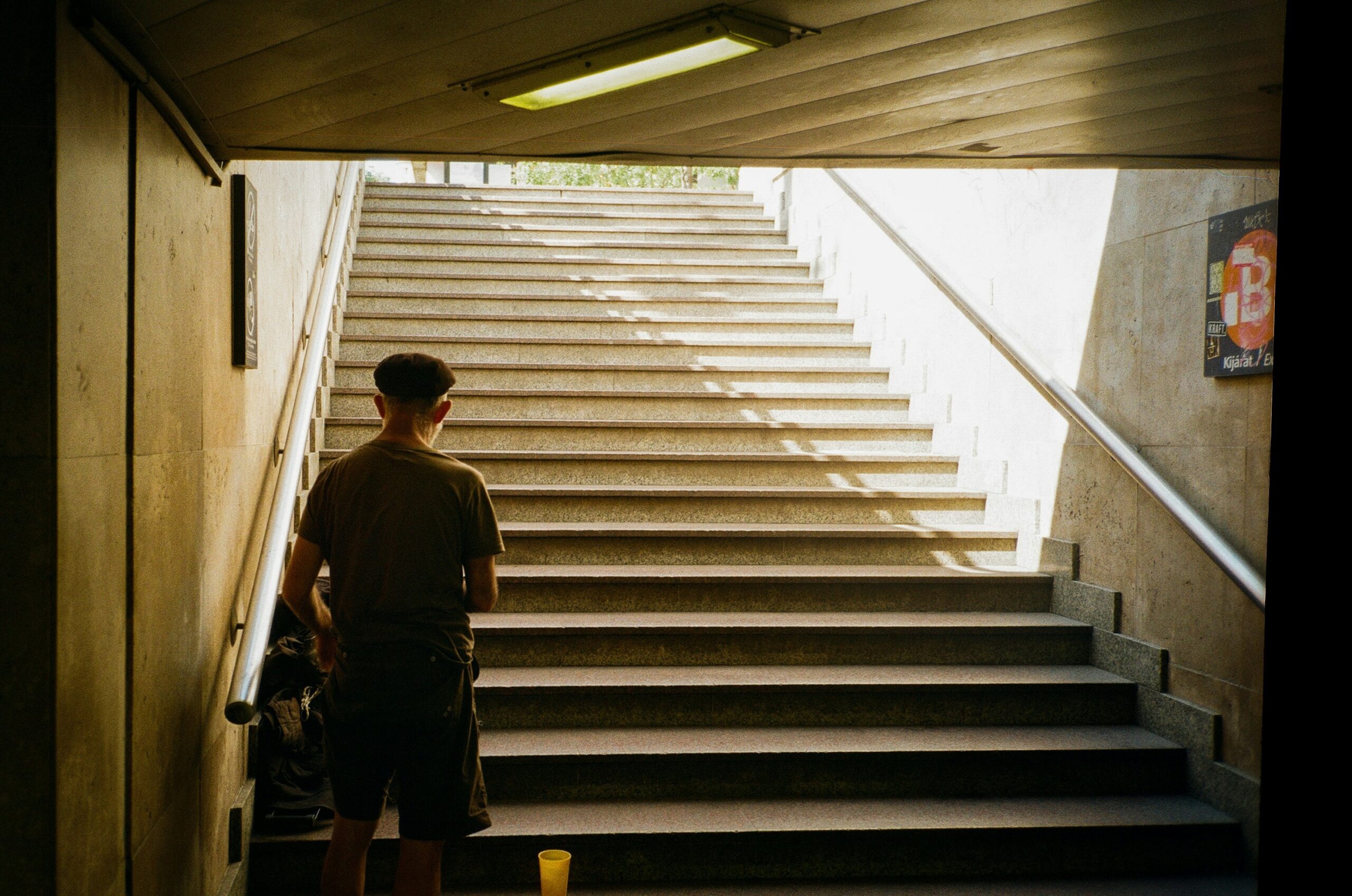 Man hugging his guide dog in front of an escalator